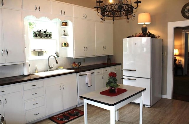 kitchen featuring sink, backsplash, white appliances, and white cabinets