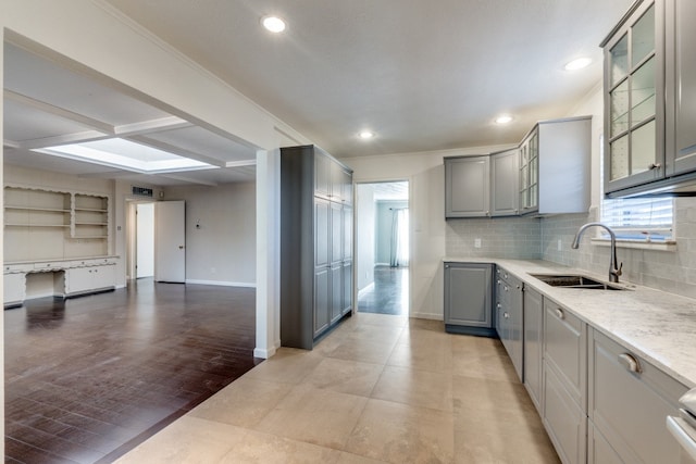 kitchen featuring sink, light stone counters, plenty of natural light, and gray cabinets