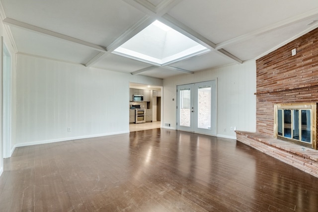 unfurnished living room featuring coffered ceiling, beamed ceiling, and a brick fireplace