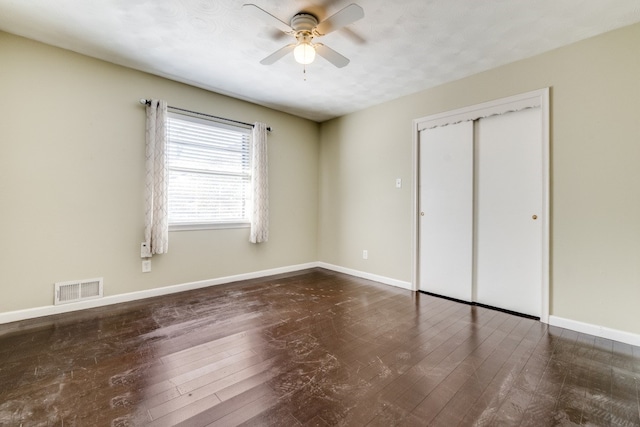 unfurnished bedroom with a closet, ceiling fan, and dark hardwood / wood-style flooring