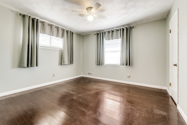 empty room featuring dark wood-type flooring and ceiling fan