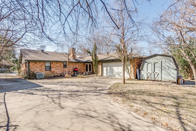 ranch-style home featuring a garage and central AC unit