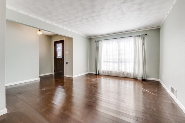 empty room with dark hardwood / wood-style flooring and a textured ceiling