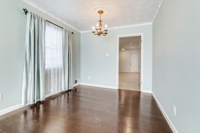 empty room with dark hardwood / wood-style floors, a notable chandelier, and ornamental molding