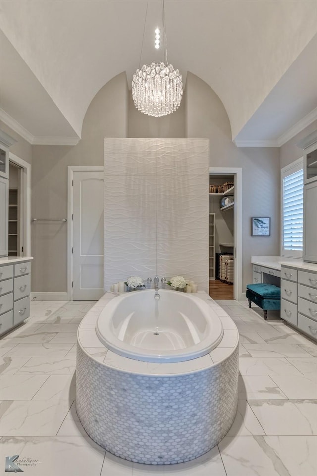 bathroom with a relaxing tiled tub, vanity, and a chandelier