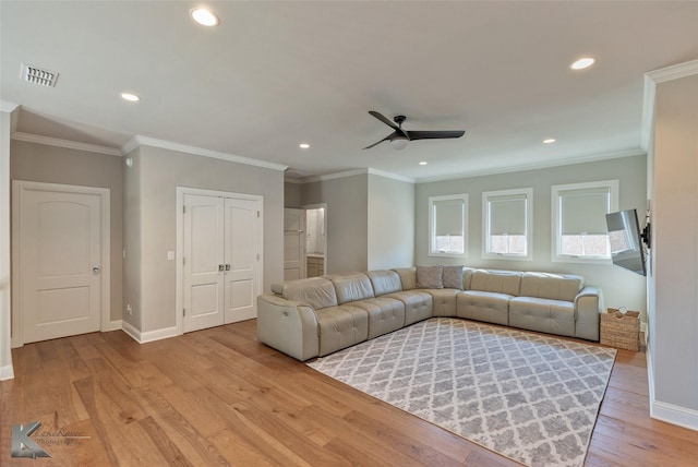 living room with crown molding, light wood-type flooring, and ceiling fan