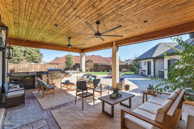 view of patio / terrace with ceiling fan, exterior kitchen, an outdoor hangout area, and area for grilling