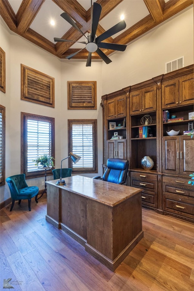 office featuring hardwood / wood-style flooring, beam ceiling, ceiling fan, and coffered ceiling