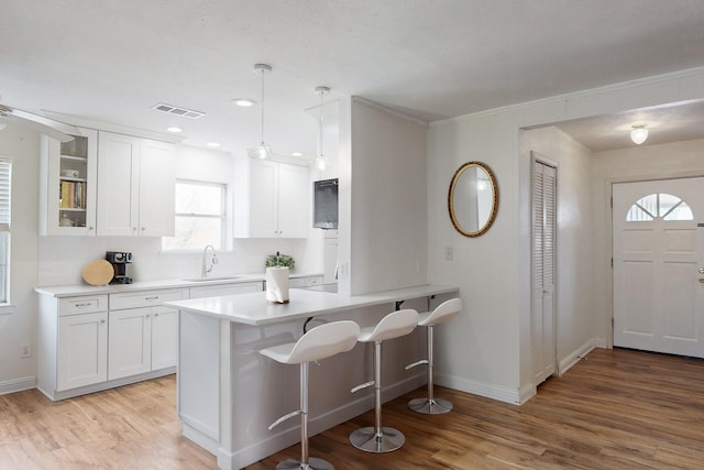 kitchen with sink, white cabinets, and hanging light fixtures