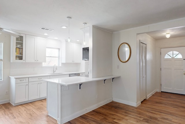 kitchen with sink, white cabinetry, and hanging light fixtures