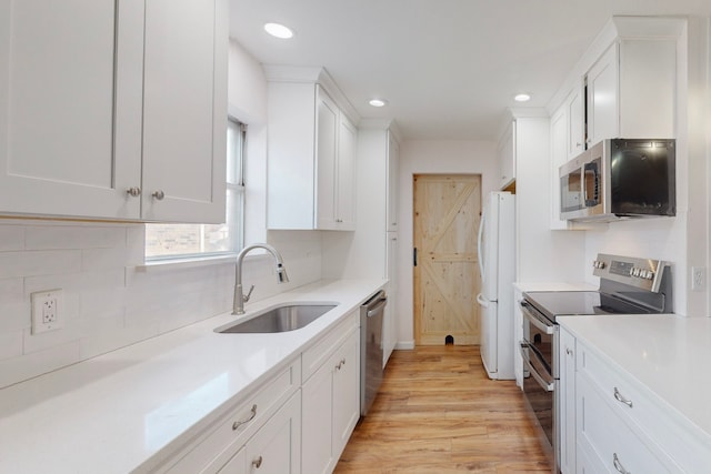 kitchen with sink, stainless steel appliances, light hardwood / wood-style flooring, and white cabinets