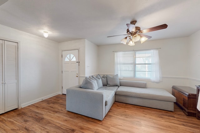 living room with ceiling fan and light wood-type flooring