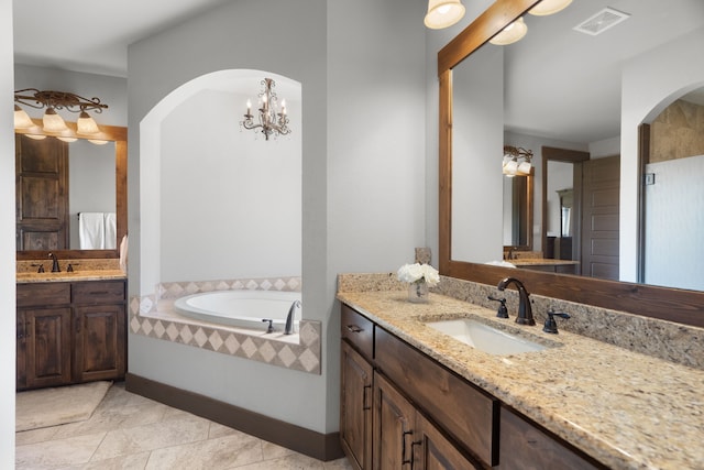 full bath with a sink, two vanities, a garden tub, and visible vents