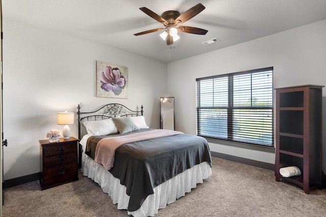 bedroom featuring visible vents, baseboards, ceiling fan, and light carpet