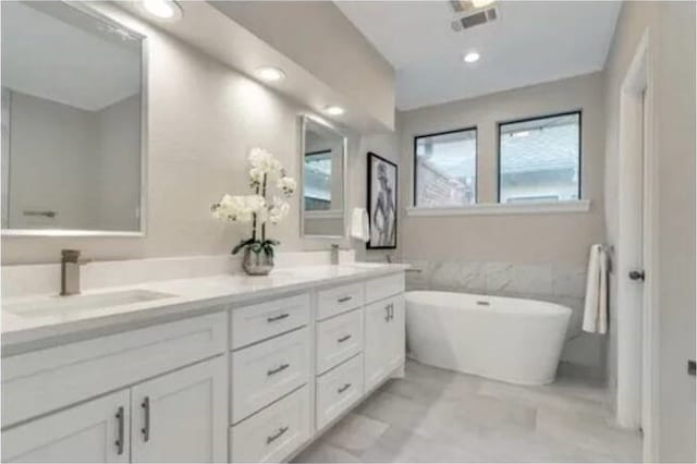 bathroom with a tub to relax in and vanity