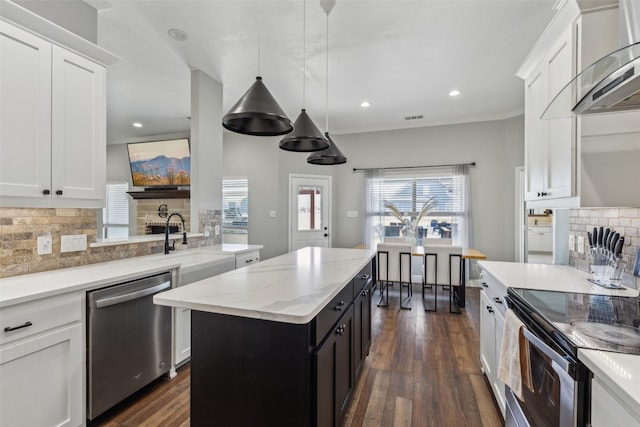 kitchen with white cabinetry, decorative light fixtures, stainless steel appliances, and a center island