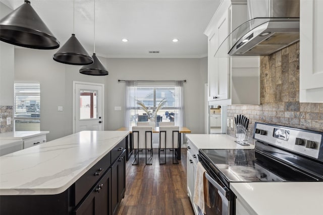 kitchen featuring extractor fan, pendant lighting, tasteful backsplash, white cabinets, and stainless steel electric range