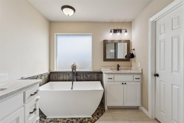 bathroom featuring vanity, tile patterned flooring, and a tub