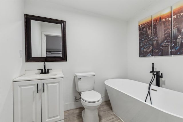 bathroom featuring toilet, vanity, a bath, and wood-type flooring