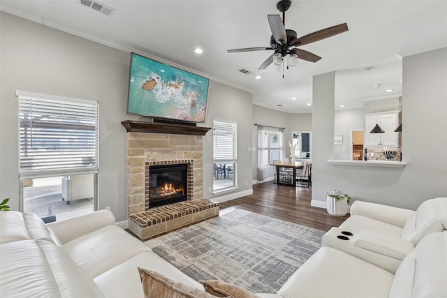 living room with hardwood / wood-style flooring, a fireplace, ornamental molding, and ceiling fan