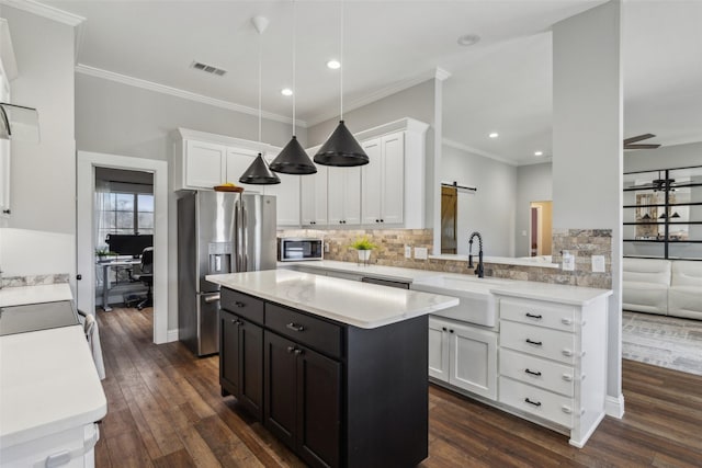 kitchen with white cabinetry, sink, a barn door, and stainless steel refrigerator with ice dispenser