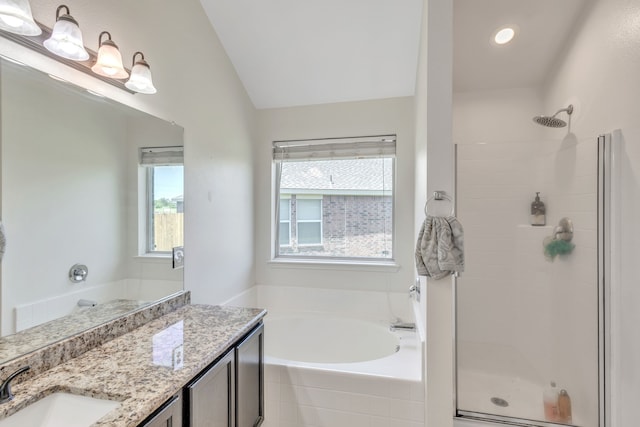 bathroom with independent shower and bath, vaulted ceiling, and vanity