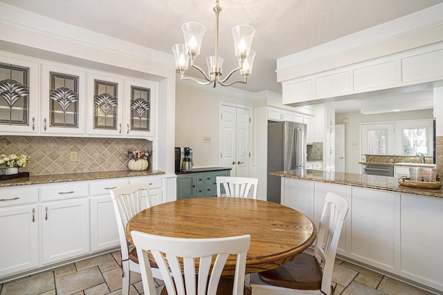 dining room featuring sink, a notable chandelier, and ornamental molding