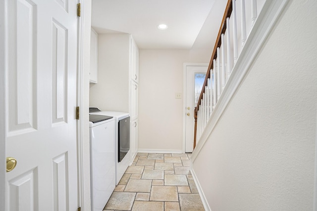 washroom featuring cabinets and washer and clothes dryer