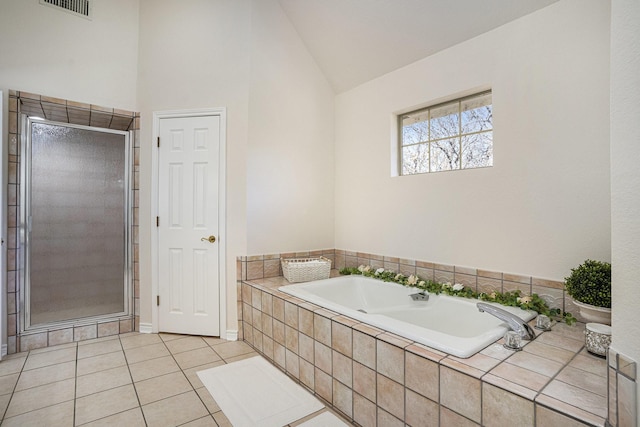 bathroom with tile patterned flooring, vaulted ceiling, and shower with separate bathtub