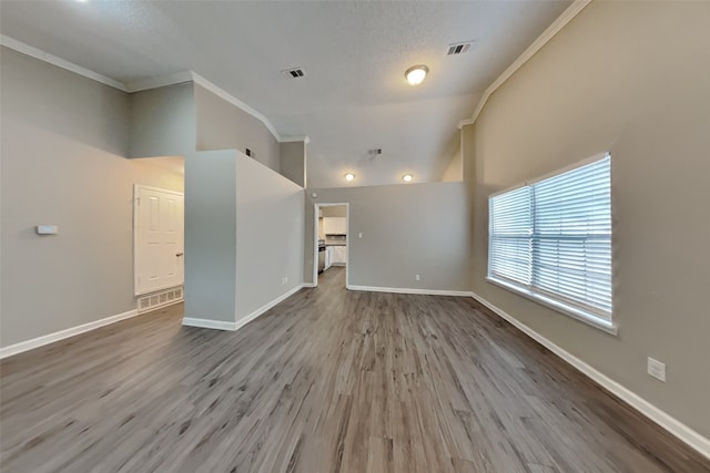 unfurnished living room featuring high vaulted ceiling, crown molding, a textured ceiling, and wood-type flooring