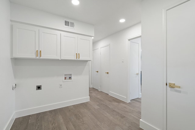 clothes washing area featuring electric dryer hookup, cabinets, light hardwood / wood-style flooring, and hookup for a washing machine