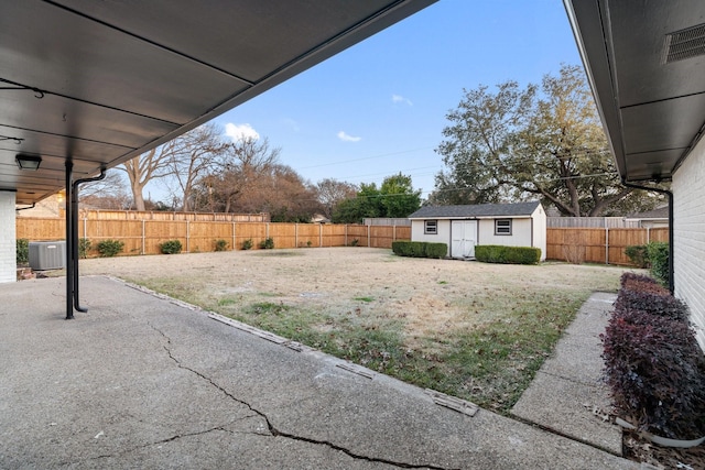 view of yard featuring a patio, central AC, and a storage unit