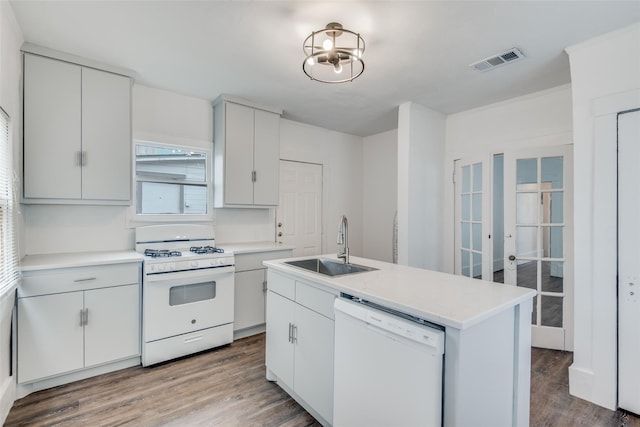 kitchen featuring white appliances, white cabinets, wood-type flooring, sink, and a center island with sink