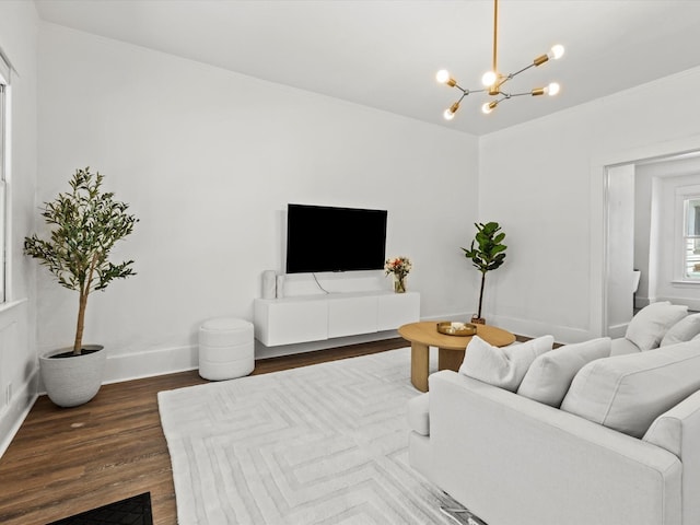 living room with hardwood / wood-style floors, an inviting chandelier, and crown molding