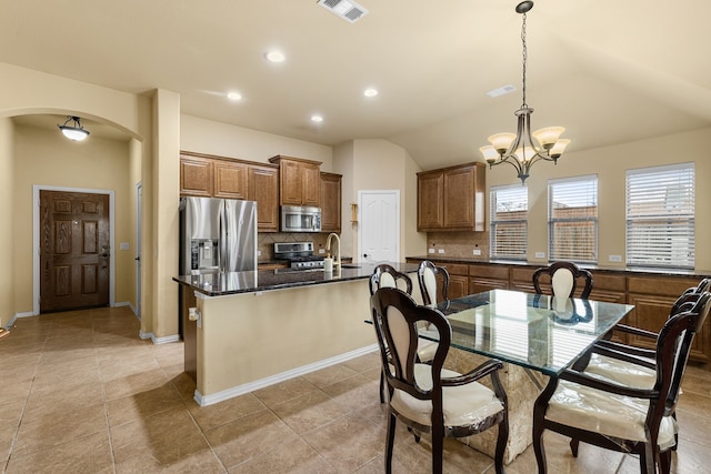 tiled dining area with sink, a chandelier, and vaulted ceiling