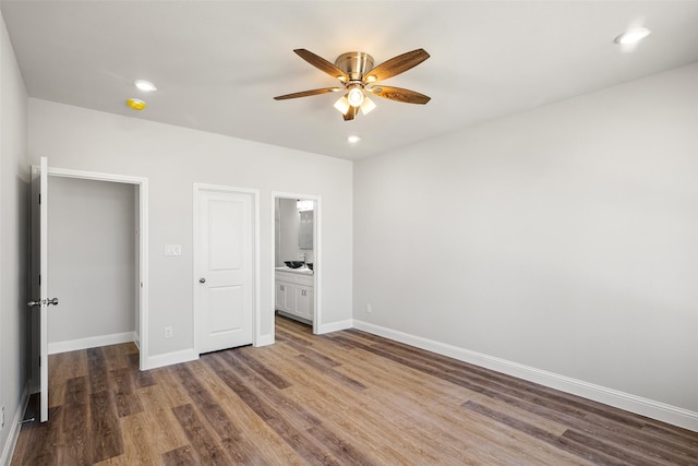 unfurnished bedroom featuring ceiling fan, connected bathroom, and hardwood / wood-style floors