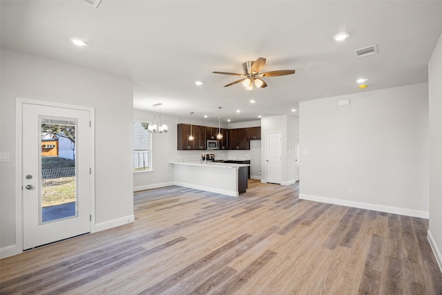 unfurnished living room with light hardwood / wood-style floors and ceiling fan with notable chandelier