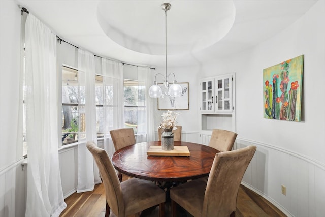 dining room featuring a notable chandelier, dark hardwood / wood-style flooring, and a tray ceiling