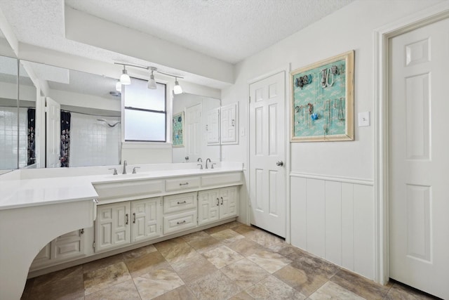 bathroom featuring vanity, walk in shower, and a textured ceiling