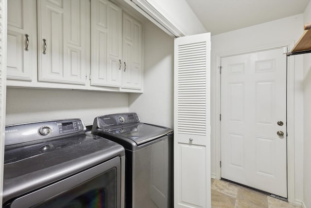 washroom with cabinets and washing machine and dryer