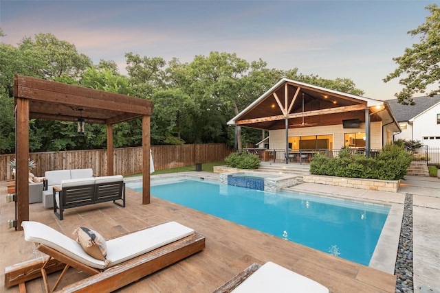 pool at dusk with a patio, an outdoor hangout area, and ceiling fan