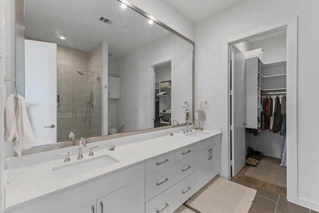 bathroom featuring vanity, an enclosed shower, tile patterned floors, and toilet