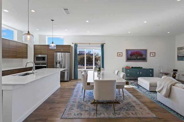 dining space featuring dark wood-type flooring and sink