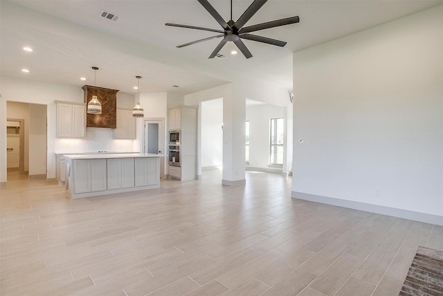 kitchen with pendant lighting, sink, backsplash, a kitchen island, and stainless steel appliances