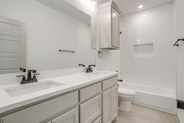 full bathroom featuring vanity, toilet, and tiled shower / bath combo