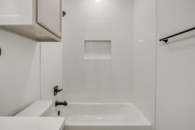 bathroom with tub / shower combination and toilet