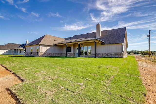 rear view of house featuring a lawn