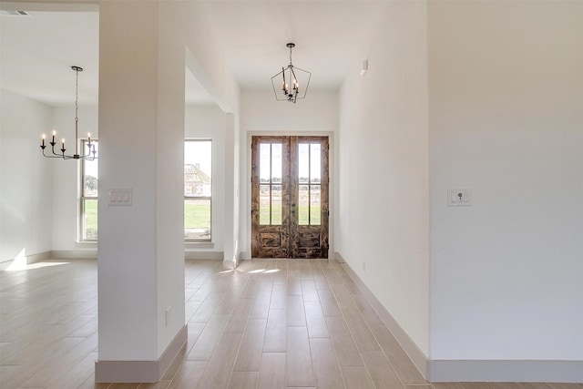 foyer entrance featuring french doors and an inviting chandelier