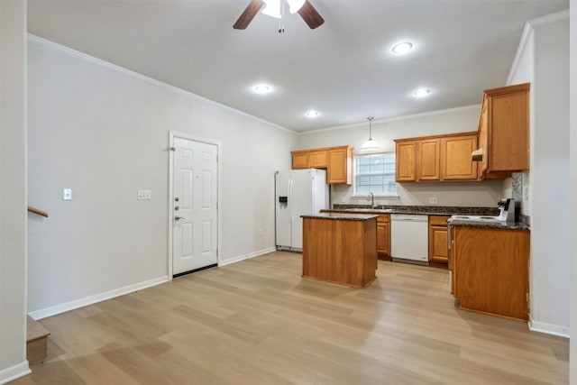 kitchen featuring a kitchen island, light wood-type flooring, white appliances, and decorative light fixtures