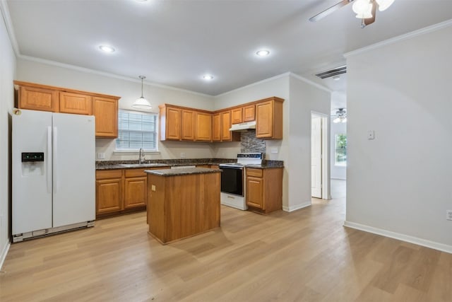 kitchen with crown molding, white appliances, and a kitchen island